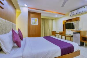 a hotel room with a bed and a kitchen at Hotel Amrit Residency in Indore
