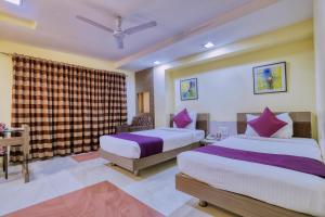 a hotel room with two beds and a window at Hotel Amrit Residency in Indore