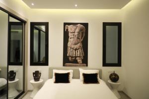 迦太基的住宿－La brise de Carthage: Earthly paradise，卧室配有一张床铺,墙上挂着雕像