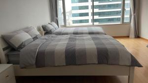 a bedroom with two beds and a large window at Hongdae Residence-4 - 1min from Hongik Univ Station #1 in Seoul