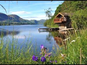 a house on a dock on a body of water at Sun Inn in Pooley Bridge