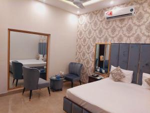 um quarto de hotel com uma cama e um espelho em Red Fort Hotel Gulberg em Lahore