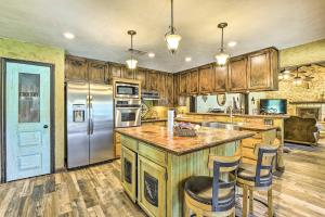 a kitchen with wooden cabinets and a stainless steel refrigerator at Sunset Ranch with Pool and Hot Tub on 29 Acres! in Sunset