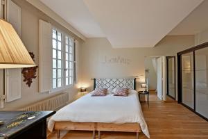 a bedroom with a bed and a desk and windows at LA BALANCE DES DOMS - 1 MIN du PALAIS des PAPES - INTRA-MUROS in Avignon
