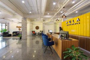 an office with a lobby with a desk and chairs at Pula Silom in Bangkok