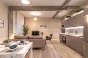 kuchnia i salon z kanapą i stołem w obiekcie Recién reformado junto a metro San Mamés w mieście Bilbao
