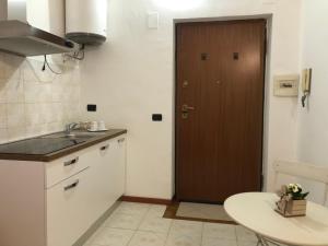 eine Küche mit einem Waschbecken und einer Holztür in der Unterkunft Mini Lambro in Mailand