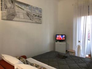 Schlafzimmer mit einem Bett, einem TV und einem Fenster in der Unterkunft Mini Lambro in Mailand