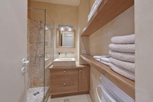 ein Bad mit einem Waschbecken, einer Dusche und Handtüchern in der Unterkunft LA BALANCE DES DOMS - 1 MIN du PALAIS des PAPES - INTRA-MUROS in Avignon