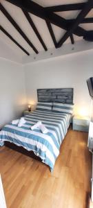 um quarto com uma cama grande com riscas azuis e brancas em Villa Lucín em Santander