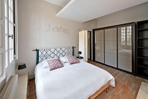 ein Schlafzimmer mit einem großen weißen Bett mit zwei Kissen in der Unterkunft LA BALANCE DES DOMS - 1 MIN du PALAIS des PAPES - INTRA-MUROS in Avignon
