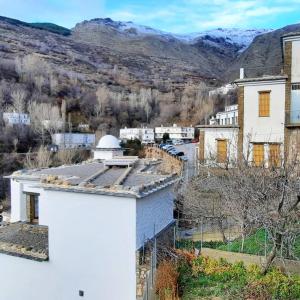 an aerial view of a white building with mountains in the background at Casa Pereza in Trevélez