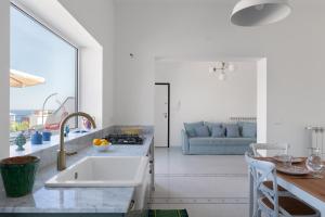 Una cocina con fregadero y una sala de estar. en Solemar Sicilia - Casa Margherita, en Santa Flavia 11 fotos más