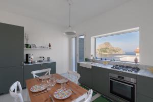 a kitchen with a table and chairs and a window at Solemar Sicilia - Casa Margherita in Santa Flavia