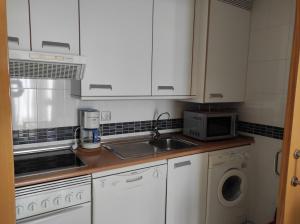 a kitchen with white cabinets and a sink and a microwave at AT home Avenida del Ejercito in Guadalajara