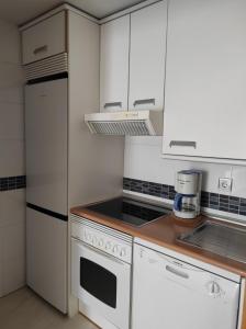 a kitchen with white appliances and white cabinets at AT home Avenida del Ejercito in Guadalajara