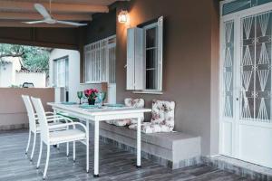 a white table and chairs on a porch with a window at The Mills House in Kallithea