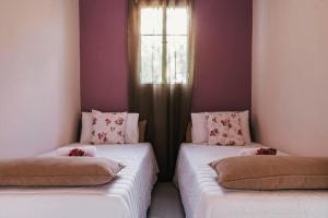 two twin beds in a room with a window at The Mills House in Kallithea