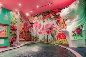 a pool in a room with a mural of flowers at Spa World HOTEL&RESORT in Osaka
