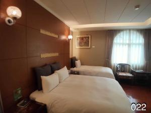 龍潭區的住宿－溫馨汽車旅館，酒店客房设有两张床和窗户。