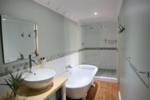 a bathroom with a sink and a toilet and a tub at Newington Place in Port Elizabeth