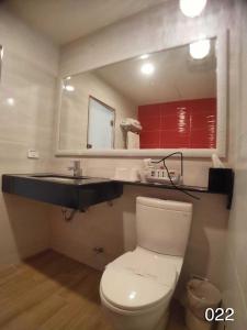 uma casa de banho com um WC, um lavatório e um espelho. em Wunsin Motel em Longtan