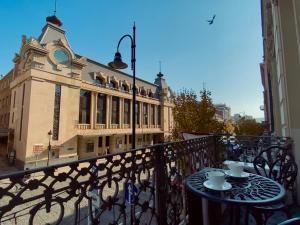 een tafel met twee kopjes op een balkon met een gebouw bij Boutique Hotel Alegria in Tbilisi City