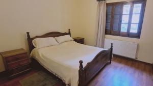 1 dormitorio con 1 cama con cabecero de madera y ventana en STAY Forest View Villa en Platres