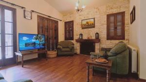 sala de estar con TV, sofá y chimenea en STAY Forest View Villa, en Platres