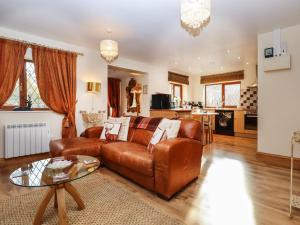 a living room with a brown leather couch and a table at The Little Lodge in Rye