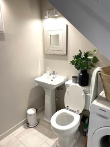 biała łazienka z toaletą i umywalką w obiekcie Cosy Camon Bolt-Hole w mieście Camon