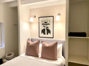 łóżko z obrazkiem mężczyzny w kapeluszu w obiekcie Cosy Camon Bolt-Hole w mieście Camon