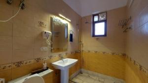 a bathroom with a sink and a toilet and a window at Luxury Cottage by iTvara in Rishīkesh