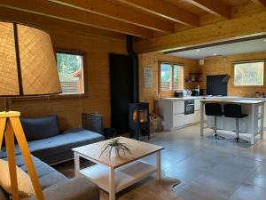 a living room with a couch and a table at Le Chalet de la Devinière, bain nordique extérieur chauffé in Xonrupt-Longemer