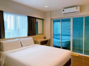 a bedroom with a bed and a bath tub in it at Miloft Sathorn Hotel - SHA Plus Certified in Bangkok