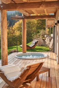 a patio with a hot tub on a wooden deck at Jakob Chalets in Perasdorf