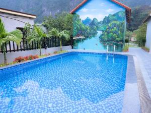 een zwembad met een muurschildering van een rivier bij Trang An Nature View Homestay in Nguyên Ngoại