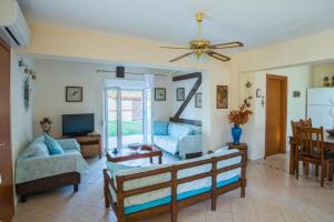 a living room with a couch and a tv at Diogenis villa in Vourvourou