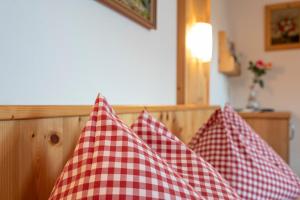 two red and white checkered pillows on a bed at Appartement Greti in Schladming