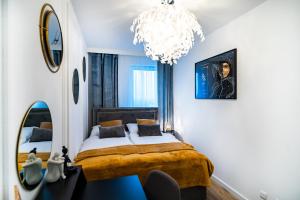 - une chambre avec un lit et un lustre dans l'établissement ApartamentySnu, Struga Tower Double Gold z parkingiem, à Radom