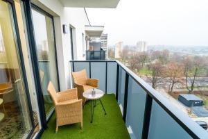 uma varanda com cadeiras e uma mesa na varanda em ApartamentySnu, Struga Tower Double Gold z parkingiem em Radom