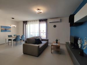 ein Wohnzimmer mit einer Couch und einem Tisch in der Unterkunft Deep Blue in Marsaskala
