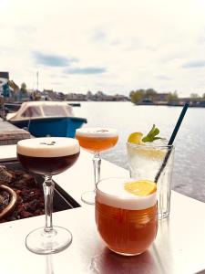tre cocktail seduti su un tavolo vicino all'acqua di Hotel Oostergoo a Grou