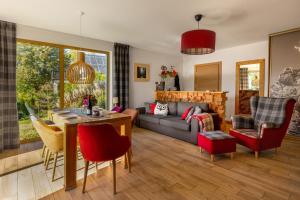 a living room with a couch and a table at Apartamenty u Harrego II Przy Stawie Spa in Kudowa-Zdrój