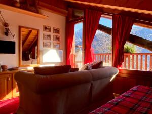 a living room with a couch and a large window at Monolocale in chalet alpino 022143-AT-010681 in Madonna di Campiglio