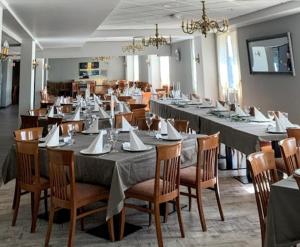 a large dining room with long tables and chairs at Storstua omsorgs- og konferansesenter in Røyken