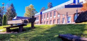 a bench in the grass in front of a building at Storstua omsorgs- og konferansesenter in Røyken