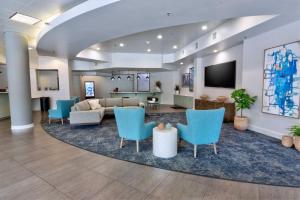 a lobby with blue chairs and a living room at Holiday Inn Gainesville-University Center, an IHG Hotel in Gainesville