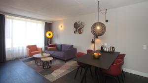 een woonkamer met een tafel en een bank bij Golden Tulip Zoetermeer - Den Haag in Zoetermeer