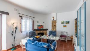 a living room with blue furniture and a fireplace at La Fresneda Cortes de la Frontera by Ruralidays in Cañada del Real Tesoro